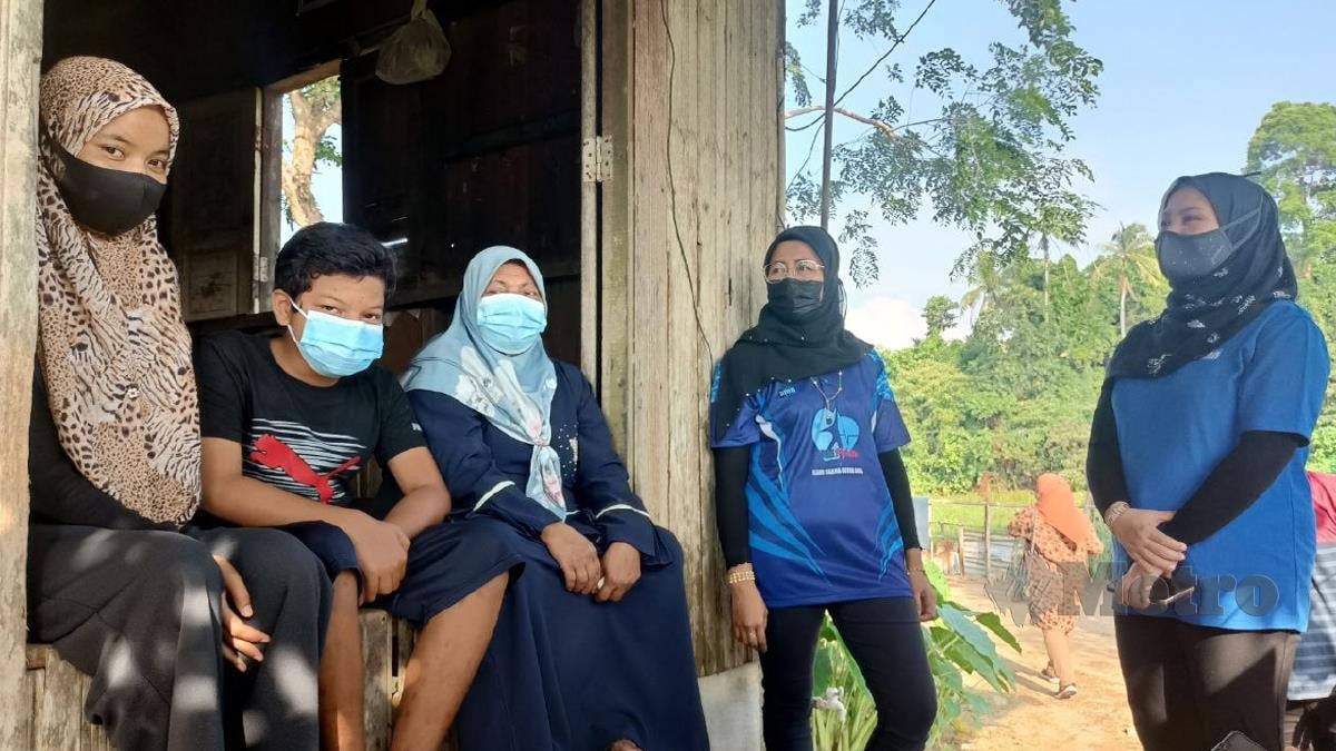 MEK Zah Mat Hassan, 56 bersama dua anaknya sambil bertanya khabar ketika ditemui di rumahnya di Kampung Tok Ku Sering, di sini. FOTO Siti Rohana Idris