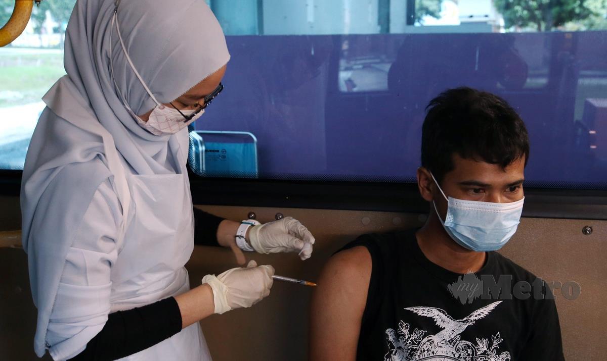 VAKSINATOR memberi suntikan vaksin Covid-19 kepada peniaga dan penjaja serta pekerja sempena Program Mobilisasi Vaksinasi Komuniti: Penang Vaksinasi Penjaja. FOTO Danial Saad 