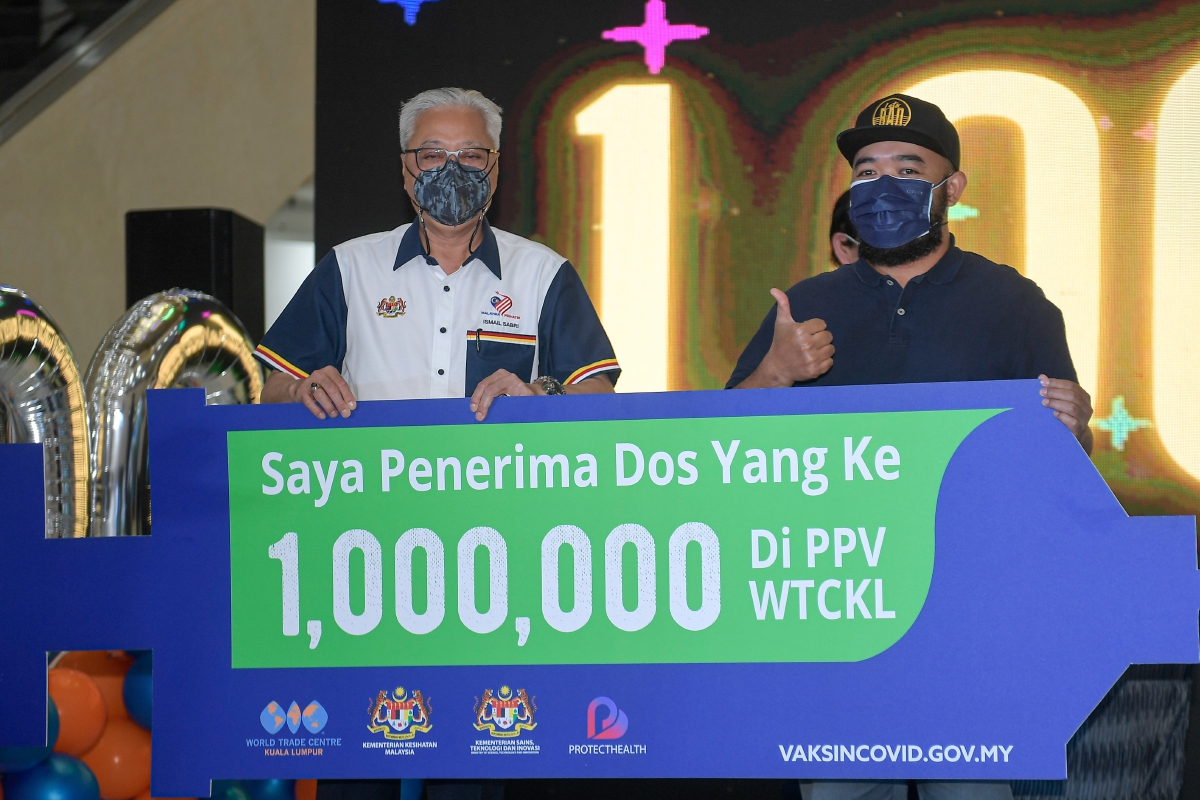 DATUK Seri Ismail Sabri Yaakob bergambar kenangan bersama penerima vaksin 1 juta dos bersama penerima. FOTO Bernama