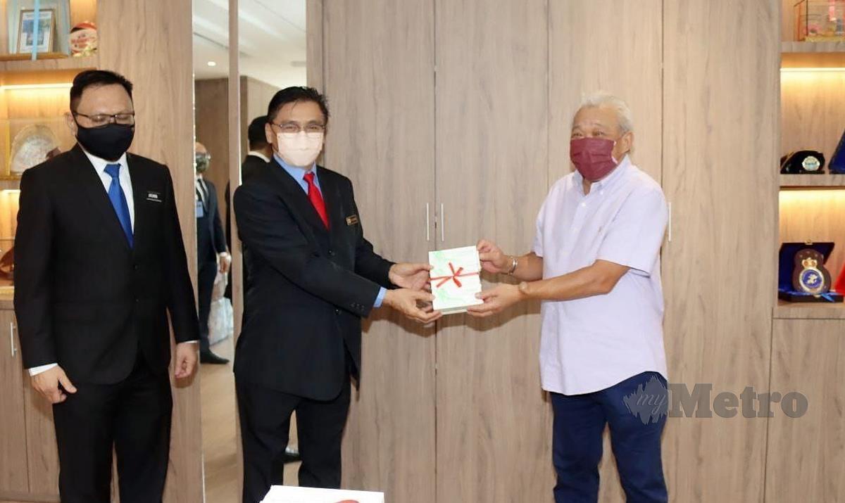 DATUK Seri Bung Moktar Radin (kanan)  menyerahkan kotak mengandungi kit ujian kendiri RTK COVID-19 kepada Pengarah JKR Sabah, Ali Ahmad Hamid. 