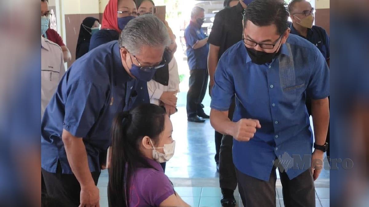 DATUK Mohamad Alamin (kanan) meninjau proses pemberian vaksin kepada murid di Sekolah Kebangsaan (SK) Malawa, Telipok di Kota Kinabalu. FOTO ihsan pembaca