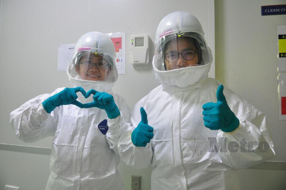 DR Zarina (kanan) bersama Profesor Madya Dr Lee Ping Chin (kiri) sebelum masuk menjalankan tugas di makmal BSL 3, UMS. FOTO Yun Mikail