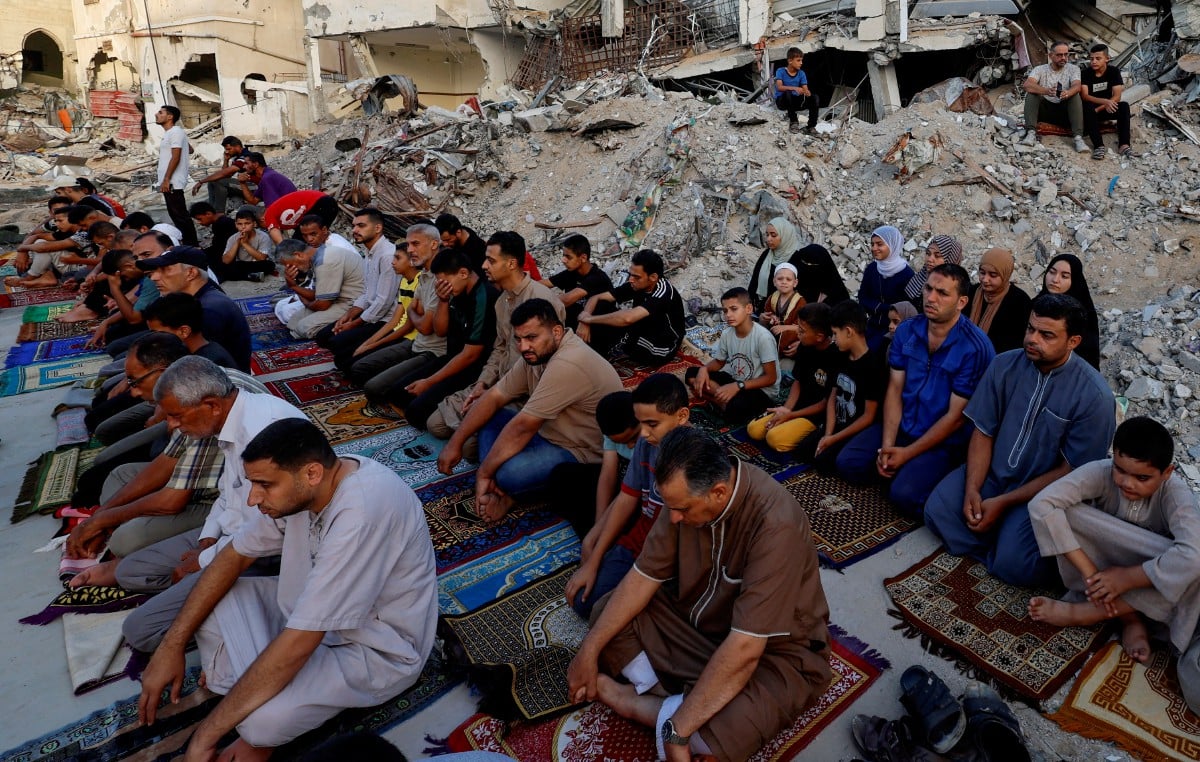 Penduduk Palestin mengadakan solat sunat Eid al-Adha di tepi runtuhan masjid Al-Rahma yang musnah akibat serangan udara Israel, di Khan Younis, di selatan Semenanjung Gaza. FOTO REUTERS