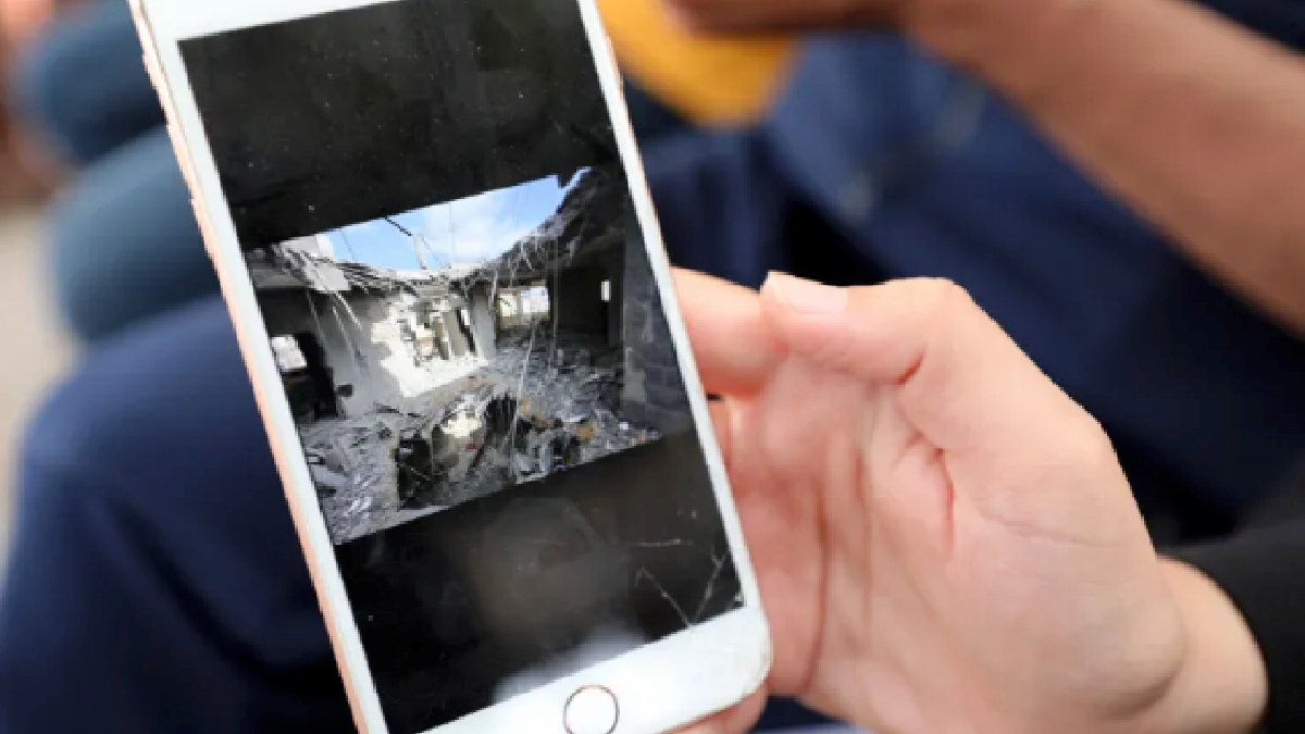 Khawla al-Khalidi menunjukkan gambar rumahnya yang musnah dibedil Israel. FOTO Al Jazeera