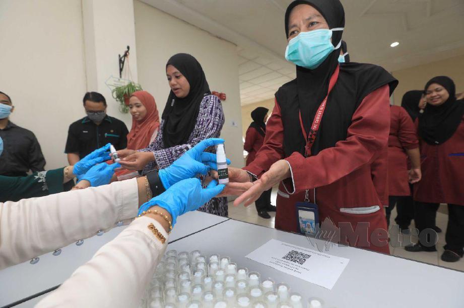 KAKITANGAN UIAM kampus Kuantan menerima 'hand sanitizer’ percuma yang disediakan Jabatan Teknologi Farmasi. FOTO Mohd Rafi Mamat