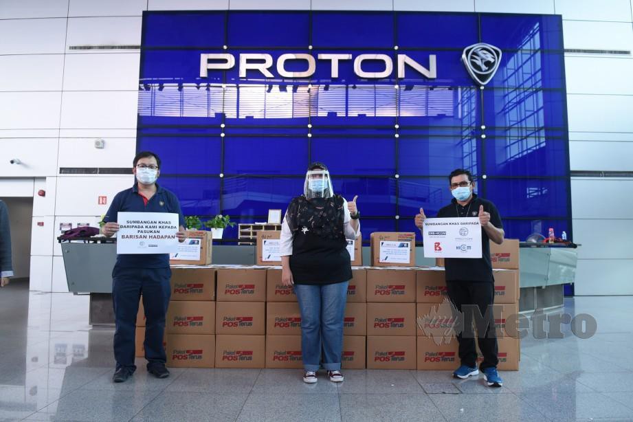 KAKITANGAN Proton bersama sebahagian kotak mengandungi penutup muka yang akan diedarkan ke hospital.