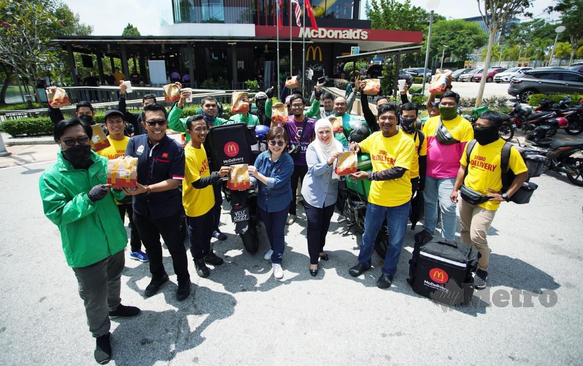 Naib Presiden dan Ketua Pegawai Pemasaran, McDonald’s Malaysia, Melati Abdul Hai (empat dari kanan) menyerahkan set hidangan percuma kepada penghantar makanan dalam program #MekdiBelanjaRider. - FOTO NSTP/Rohanis Shukri