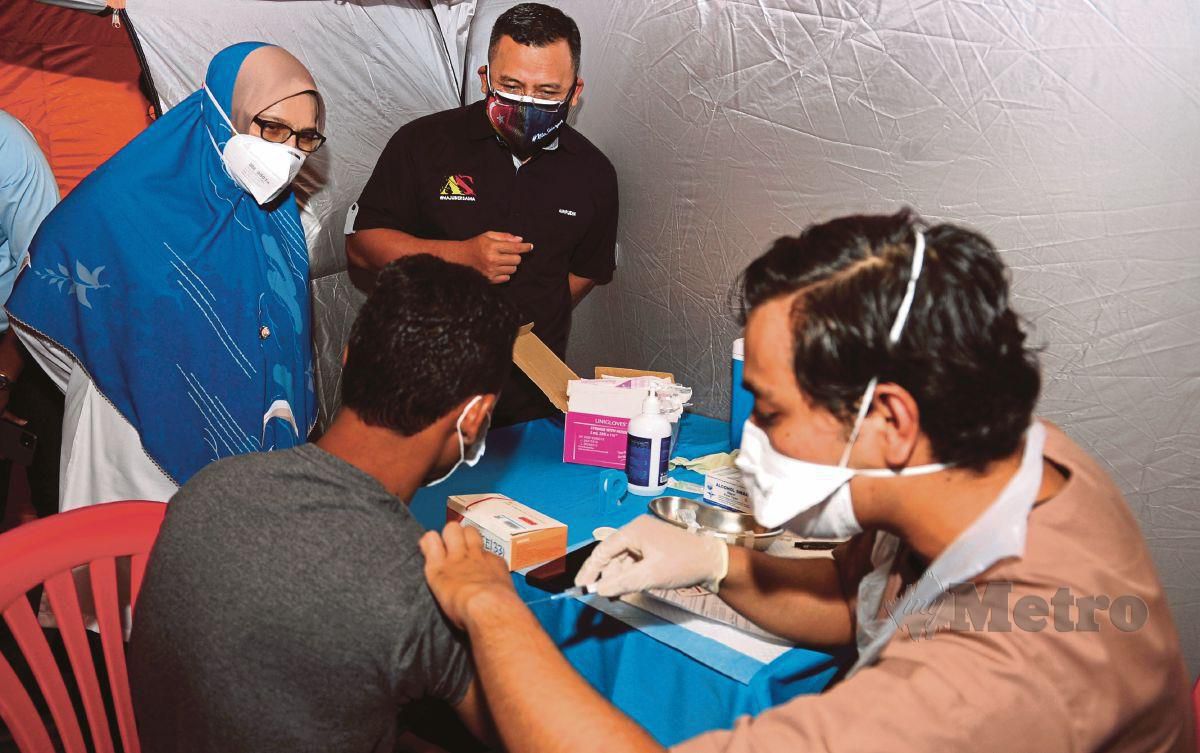 DATUK Seri Amirudin Shari (dua dari kiri) dan Dr Siti Mariah Mahmud (kiri) melihat proses suntikan vaksin COVID-19. FOTO Bernama