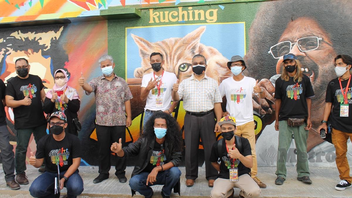 MASRI (empat dari kanan) bersama pelukis yang menjayakan projek mencantikkan Lorong Seni Seremban dengan gambar mural sempena Seremban 100 tahun, hari ini. FOTO Mohd Amin Jalil