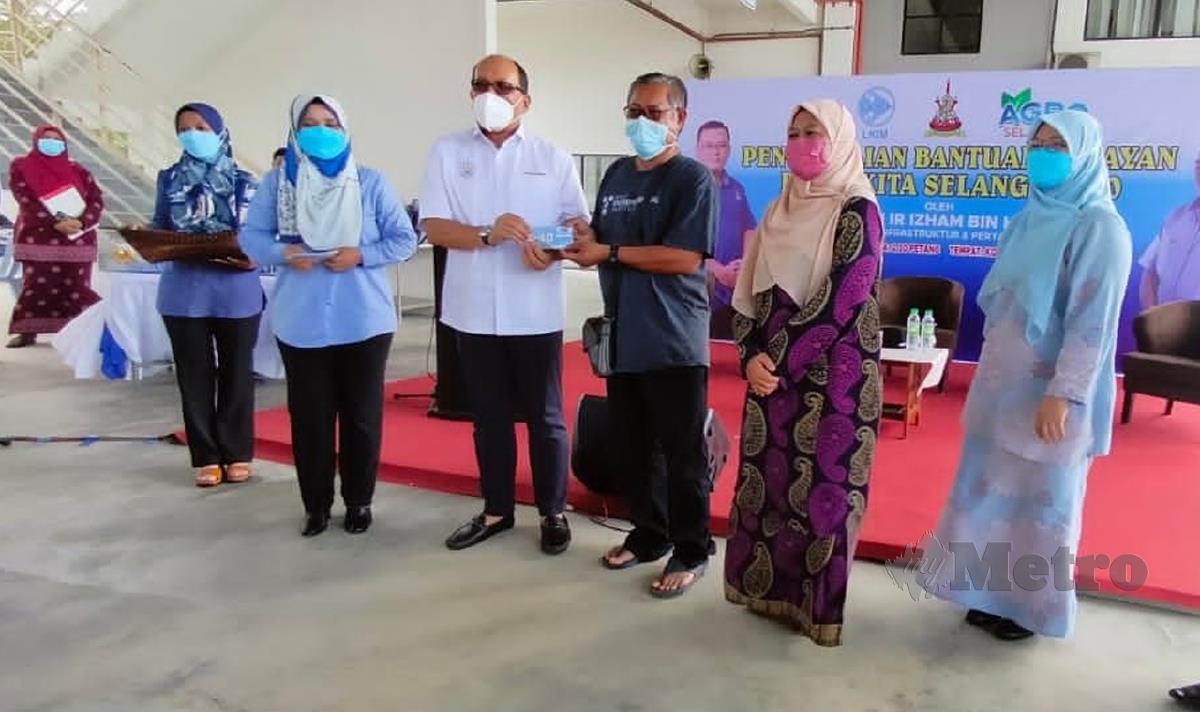 IZHAM Hashim (tengah) menyampaikan subsidi minyak petrol kepada salah seorang penerima dalam Majlis Penyampaian Bantuan Nelayan Pakej Kita Selangor 2.0. FOTO Amirul Aiman Hamsuddin