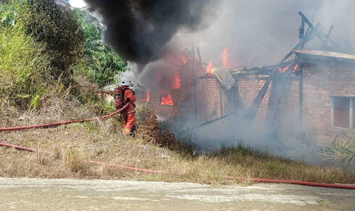 PASUKAN bomba sedang giat memadam kebakaran yang memusnah Rumah Panjang Ason di Tembawai Kapok pagi tadi. FOTO Erika George