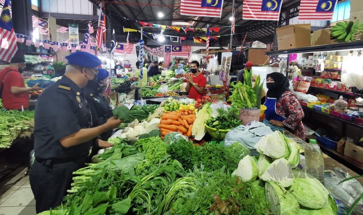 PEGAWAI penguatkuasa KPDNHEP negeri memantau penjualan sayur di Pasar Cabang Tiga, hari ini. FOTO Baharom Bakar