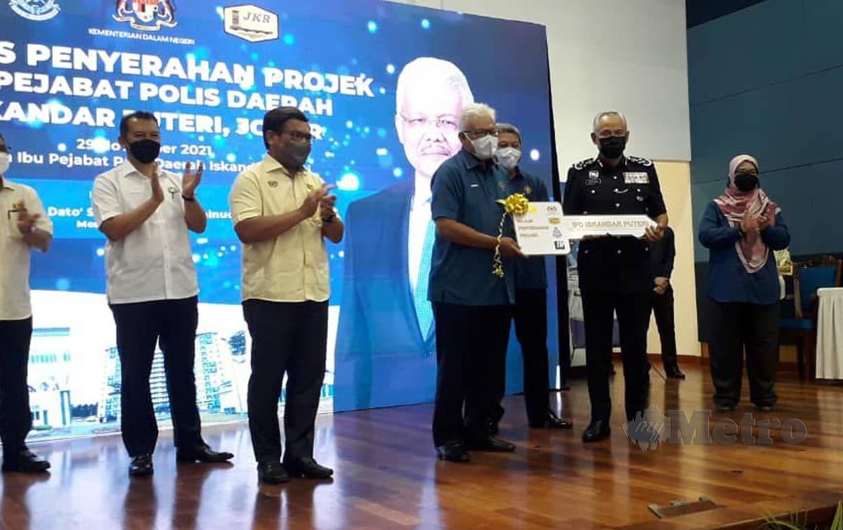 DATUK Seri Hamzah Zainudin (tengah) menyerahkan replika kunci kepada Datuk Seri Acryl Sani Abdullah Sani (kanan). FOTO Nurul Amanina Suhaini