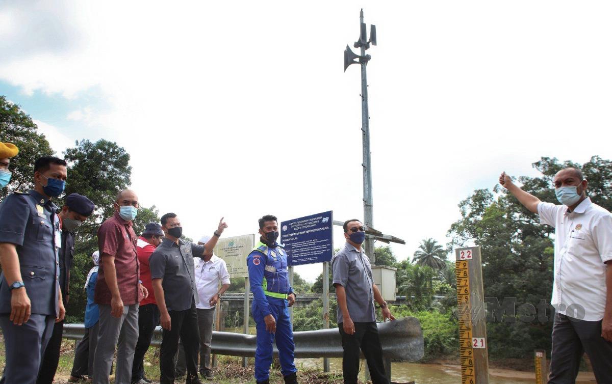 OSMAN (kanan) meninjau stesen siren amaran awal banjir yang dipasang di tebing sungai Kampung Pengkalan Ajal. FOTO Ghazali Kori