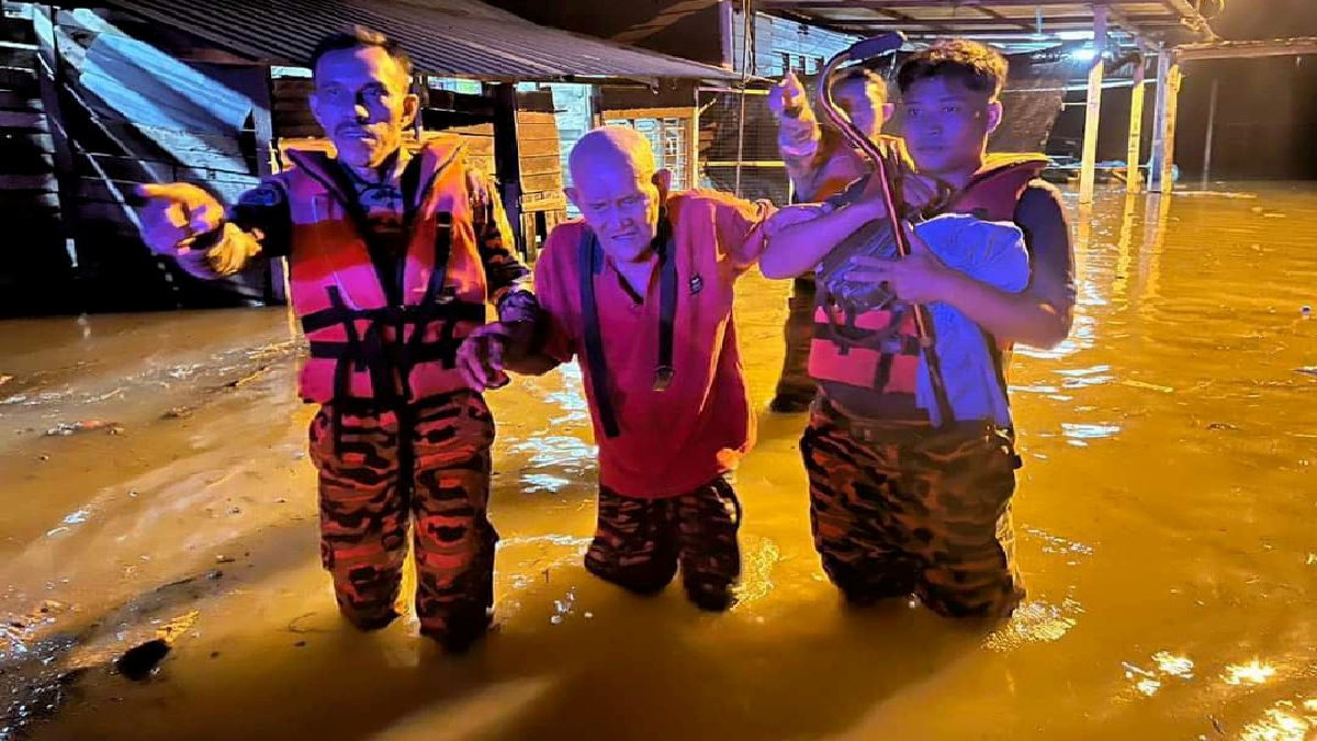  Anggota bomba membantu memindahkan mangsa banjir di Changkat Jong ke PPS Dewan Serbaguna Padang Tembak. FOTO IHSAN BOMBA.
