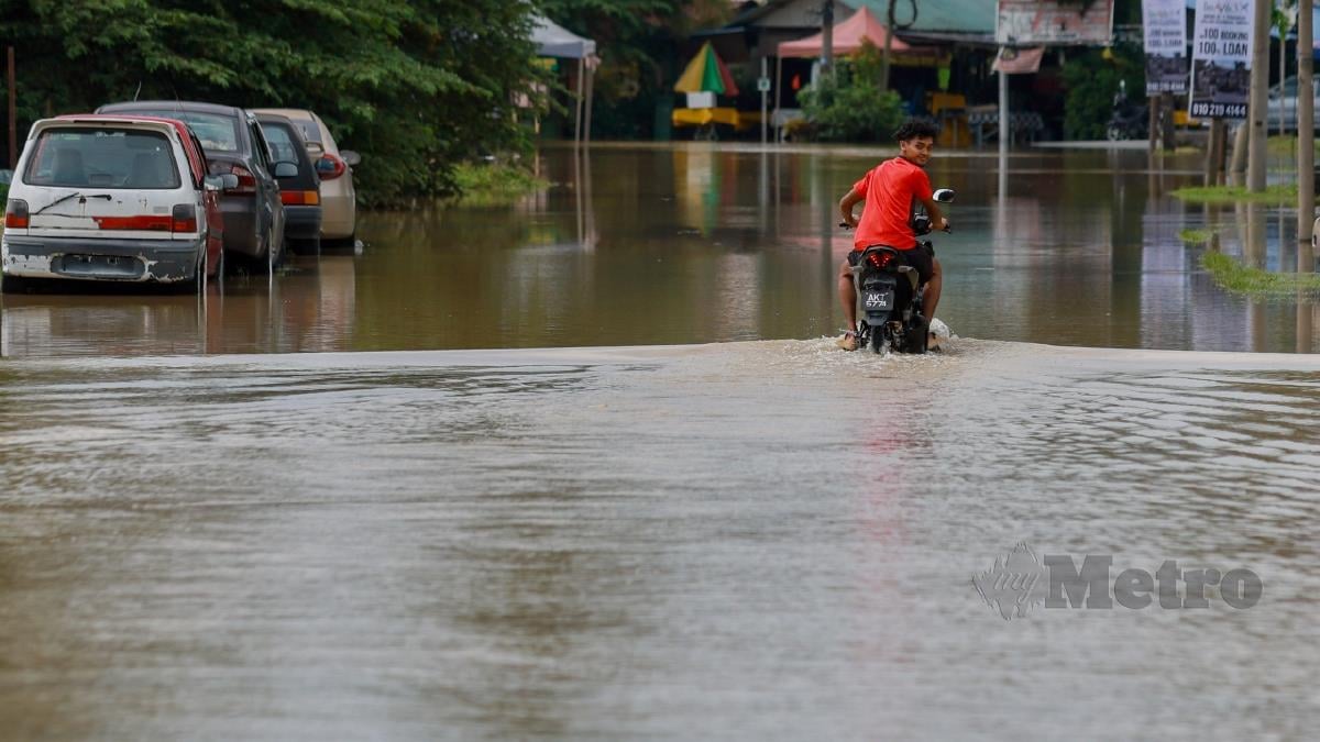 Keadaan jalan di Jalan Teratai dilimpahi air berikutan Sungai Binjai di Pekan Meru, Klang. FOTO ASYRAF HAMZAH