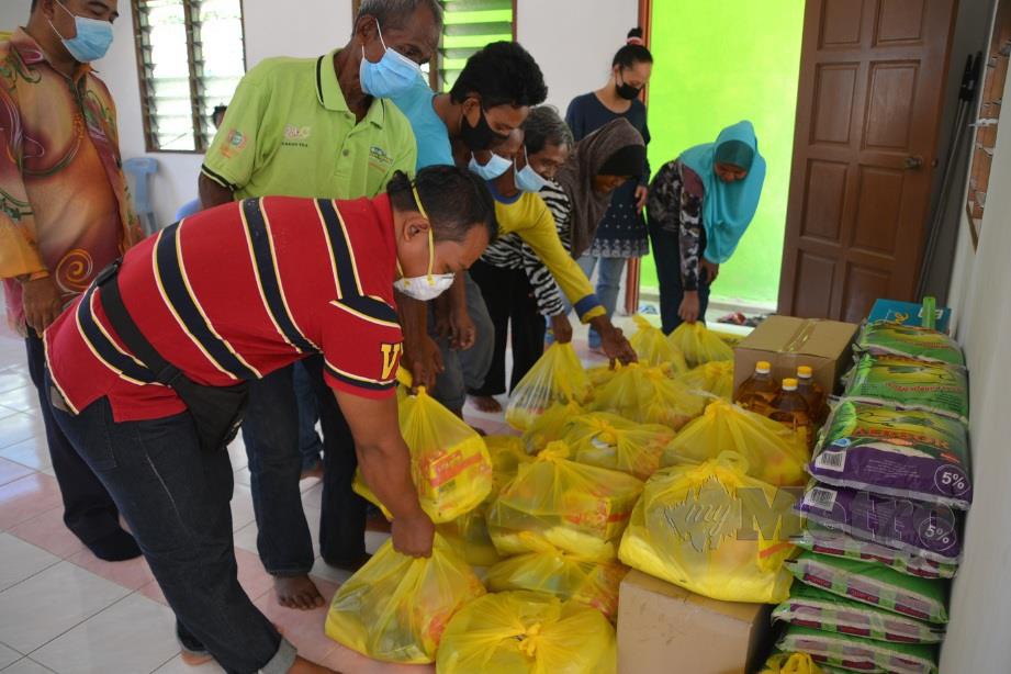 ORANG Asli menyusun bahan makanan sumbangan JAKIM di Kampung Bukit Sebang, Alor Gajah. FOTO Hassan Omar