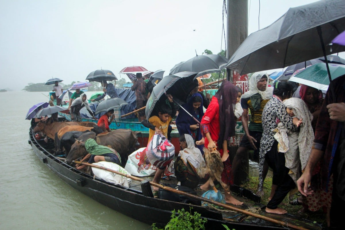 Orang awam menaiki bot untuk menyelamatkan diri selepas kediaman mereka di Sylhet ditenggelami air. - FOTO AFP