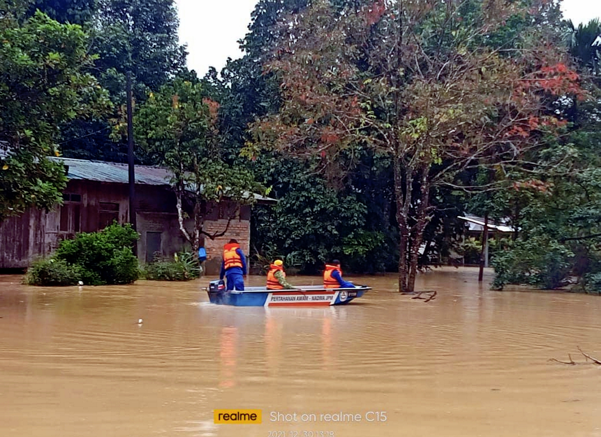 ANGGOTA APM Jeli menjalankan operasi memindahkan mangsa banjir di Kampung Legeh, Jeli yang mula dinaiki air. FOTO Ihsan APM Jeli