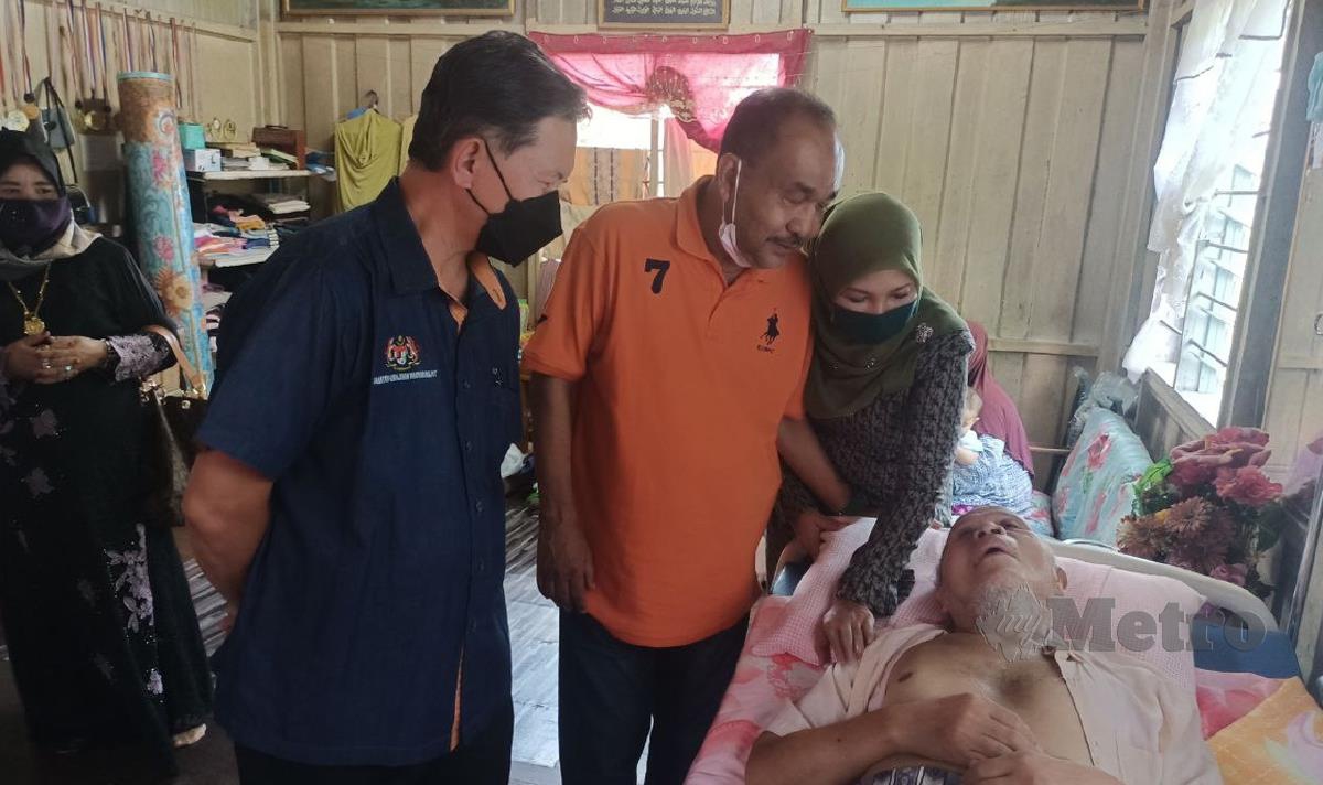 SAID Sidup (kiri) melihat keadaan warga emas, Nik Hassan Nik Abas, 73, yang menghidap Parkinson di Kampung Surau, Pasir Pekan di sini. FOTO Siti Rohana Idris