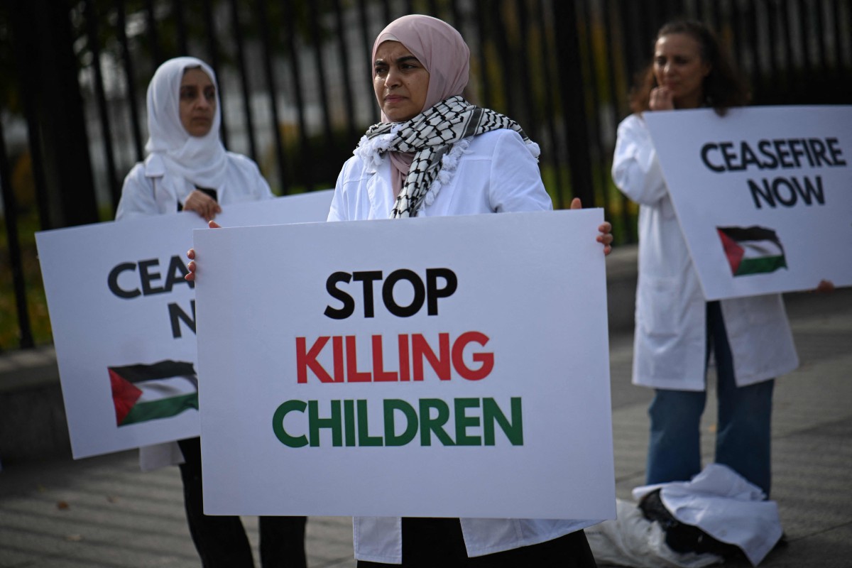 Peserta demonstrasi membawa poster menggesa serangan di Gaza dihentikan. - FOTO AFP