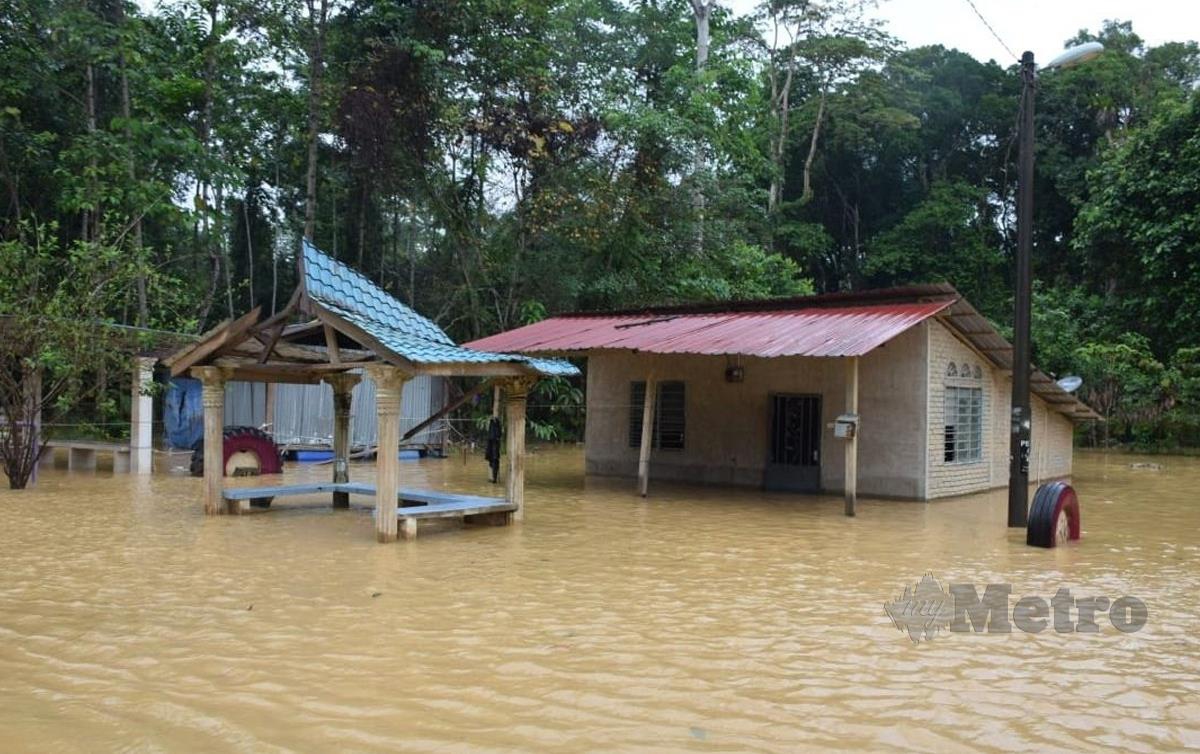 AIR banjir kini mula melimpah di atas jalan raya di kawasan Paya Garuk, laluan utama ke Taman Negara. FOTO Roselan Ab Malek