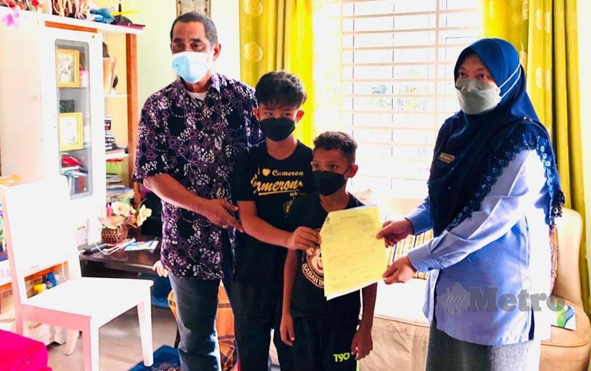 FARIHAH (kanan) menyampaikan faedah pengurusan jenazah kepada Zamri Sulong, 62, (kiri) suami Rubiah Omar, 39, yang meninggal dunia akibat ketumbuhan dalam kepala. FOTO Zaid Salim