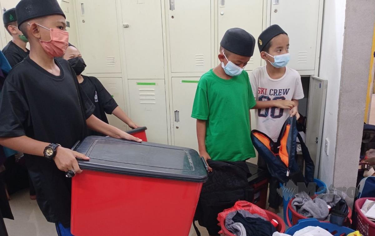 SEBAHAGIAN pelajar Pondok Darul Syahadah mengemas barang-barang mereka selepas diarah keluar oleh pemilik bangunan. FOTO Nor Amalina Alias 