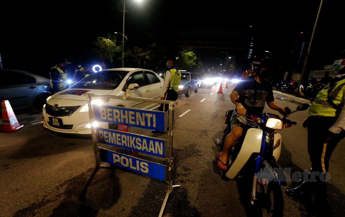 ANGGOTA trafik memeriksa pemandu kereta dan penunggang motosikal ketika Operasi Cegah Jenayah sempena Tahun Baru Cina di Jalan Utara, Petaling Jaya. FOTO Hairul Anuar Rahim 