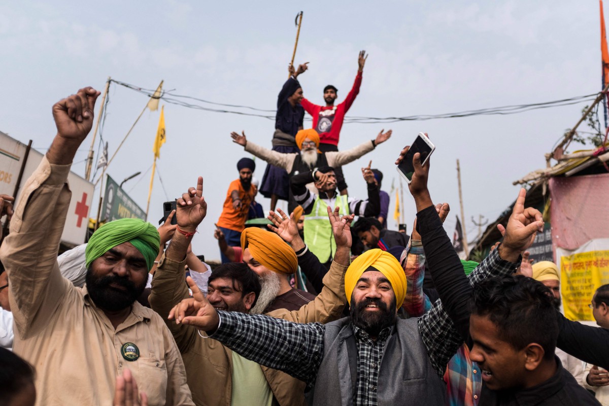 Petani di Singhu, India meraikan pengumuman pemansuhan tiga undang-undang pertanian yang sebelum ini mencetuskan protes besar-besaran hampir setahun. - FOTO AFP