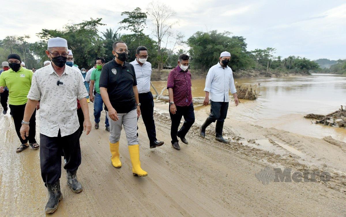 DATUK Seri Dr. Samsuri Mokhtar (dua dari kiri) semasa meninjau kawasan yang terjejas banjir di Kampung Teladas, Air Putih. FOTO Ghazali Kori