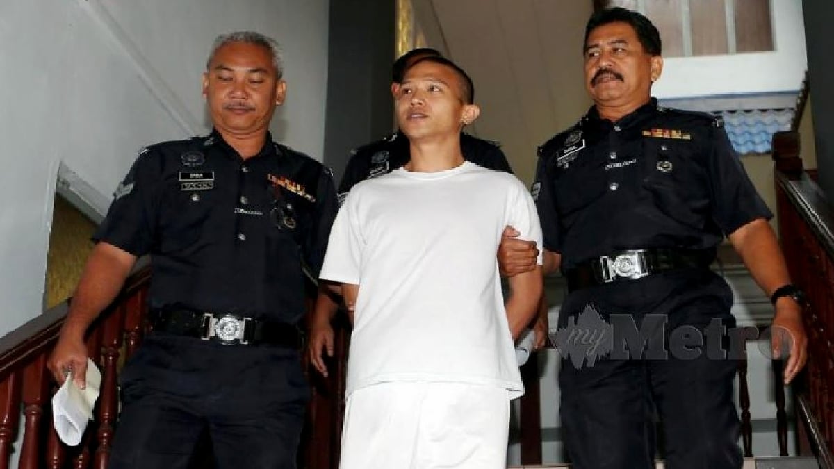 Luqman Hadi diiringi anggota polis keluar dari Mahkamah Tinggi Melaka dijatuhkan hukuman gantung sampai mati pada 2019 kerana membunuh tiga ahli keluarga angkatnya. FOTO Arkib NSTP