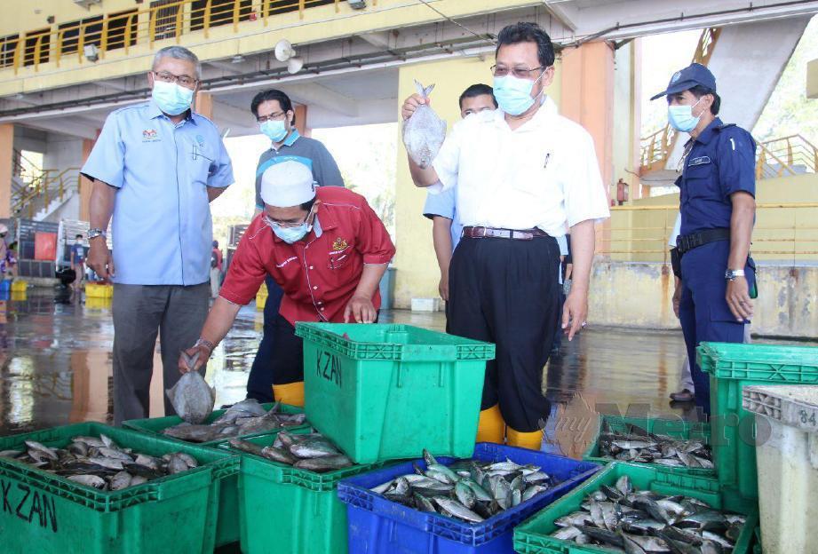 NELAYAN mengasingkan  ikan mengikut jenis yang baru dinaikkan sebelum dijual kepada pemborong idi Pelabuhan Kompleks Lembaga Kemajuan Ikan Malaysia (LKIM), Tok Bali. FOTO Nik Abdullah Nik Omar