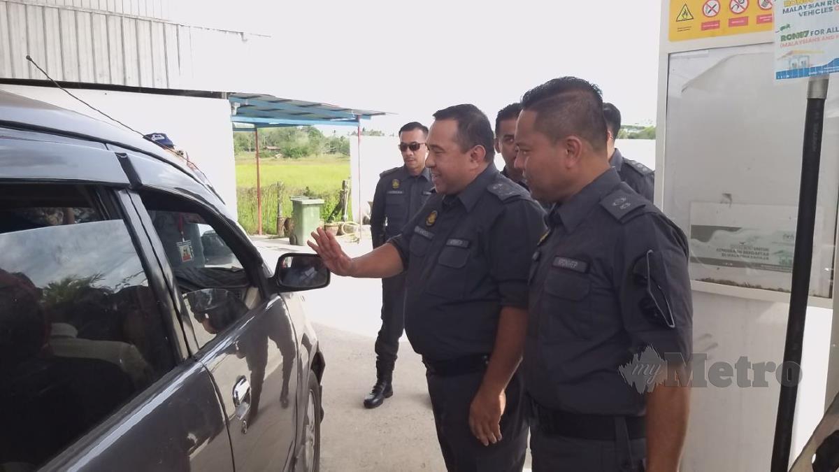 SHAMSUL (dua dari kanan) menerangkan sesuatu terhadap pemandu kereta tempatan terhadap penguatkuasaan larangan jualan petrol dan diesel bersubsidi kepada kenderaan asing di sebuah stesen petrol di Titi Tinggi, Padang Besar. FOTO AIZAT SHARIF