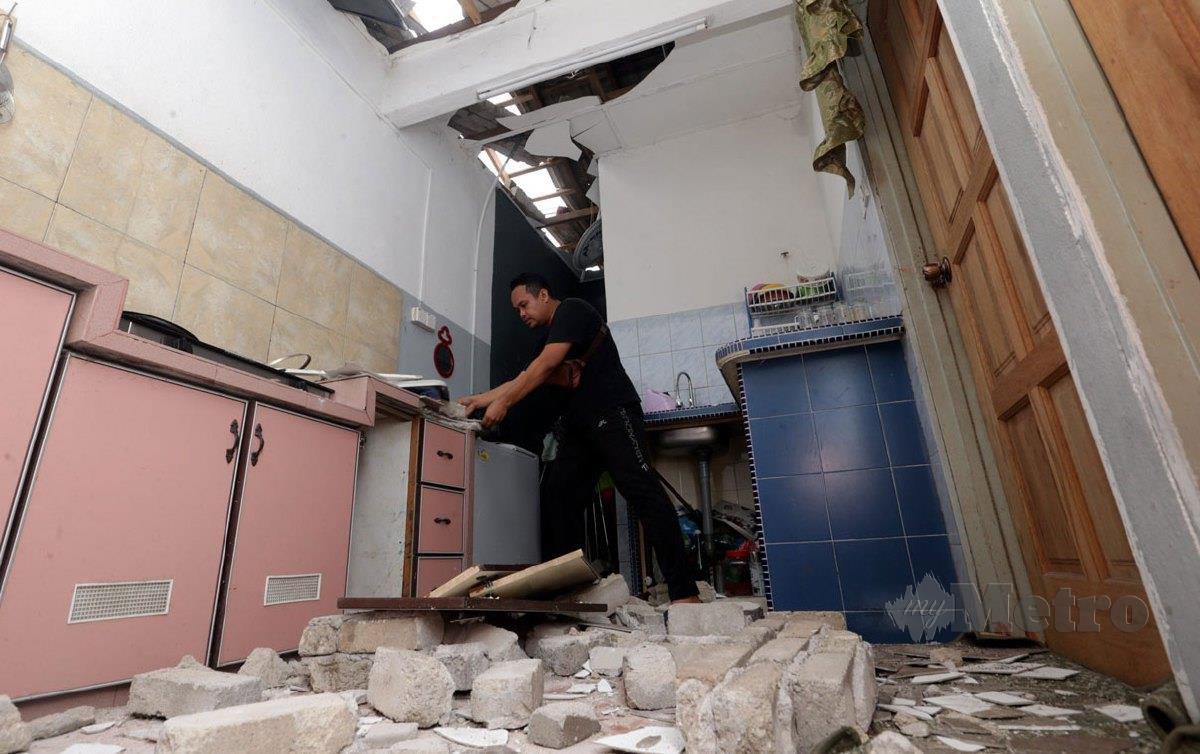 MOHD Hashim Ahmad, 41, bahagian dapur rumahnya yang rosak teruk kesan akibat dipercayai letupan rumah jirannya di Taman Cenderawasih, Jawi di sini. FOTO Danial Saad