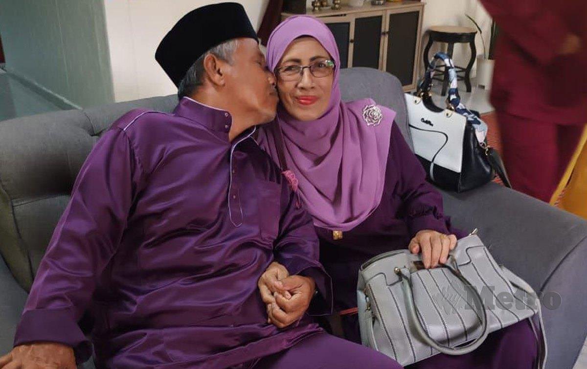 MD Yunus Baba (kiri) mencium isterinya di rumah mereka di Lendu, Alor Gajah. FOTO Nazri Abu Bakar