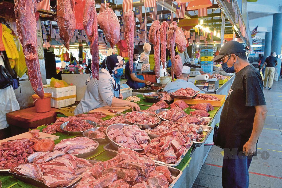 SEORANG peniaga daging di Pasar Moden Seksyen 6, Shah Alam menjual daging segar untuk pelanggan membeli. FOTO Faiz Anuar