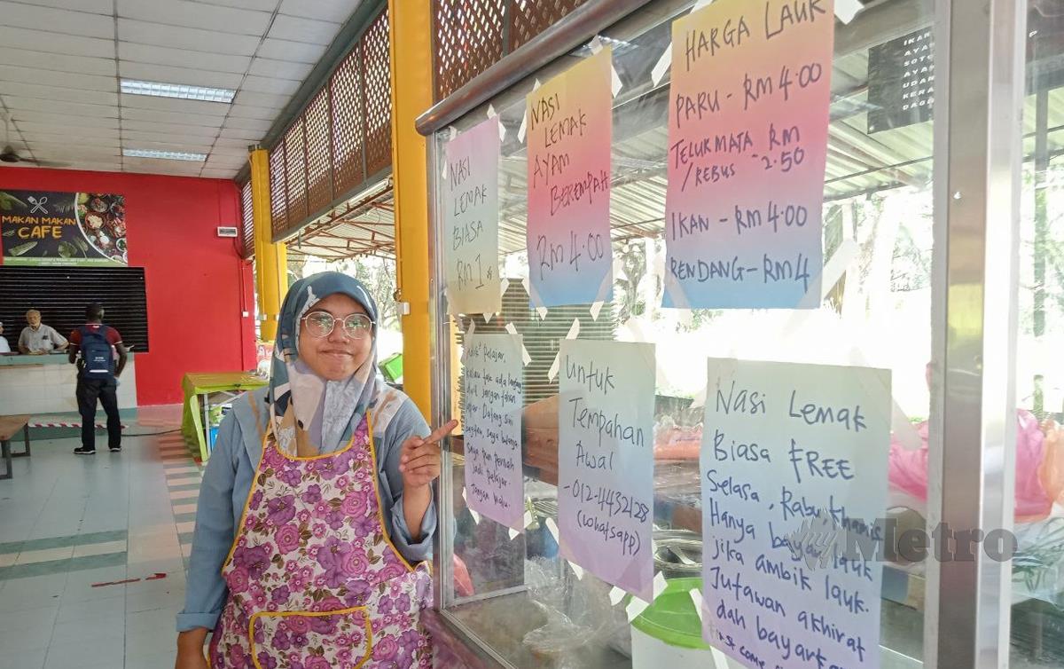 Siti Aisyah menunjukkan nota yang ditampal untuk pelajar mendapatkan nasi lemak secara percuma. FOTO Omar Ahmad