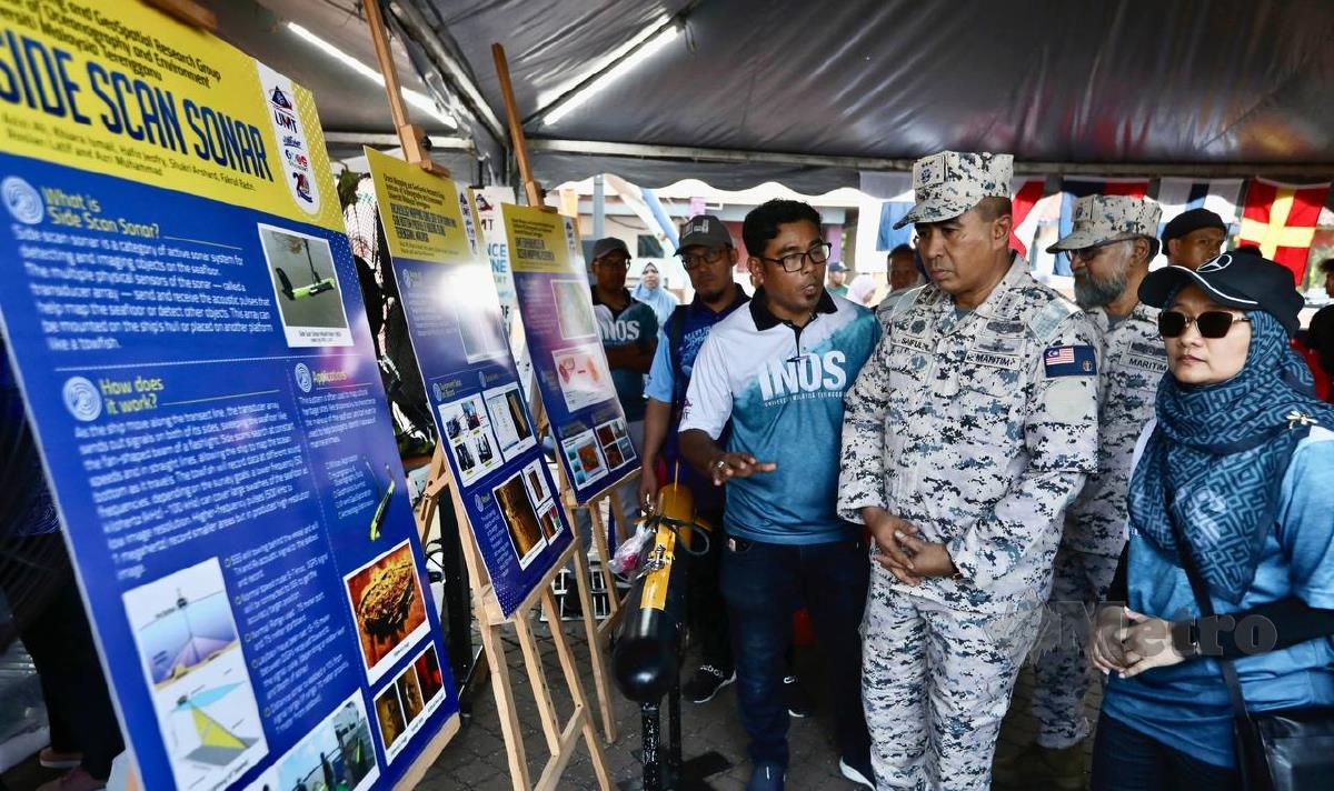 DATUK Saiful Lizan Ibrahim (dua kanan) melawat gerai pameran sempena sambutan Hari Kesedaran Keselamatan Maritim Peringkat Kebangsaan di Pantai Batu Buruk di sini semalam. FOTO Ghazali Kori