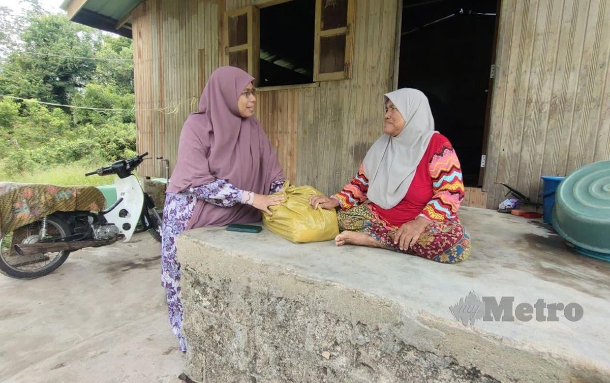 DATUK Siti Zailah Mohd Yusoff, menyampaikan sumbangan keperluan asas dan tilam kepada salah seorang mangsa banjir di sini, hari ini. FOTO Syaherah Mustafa