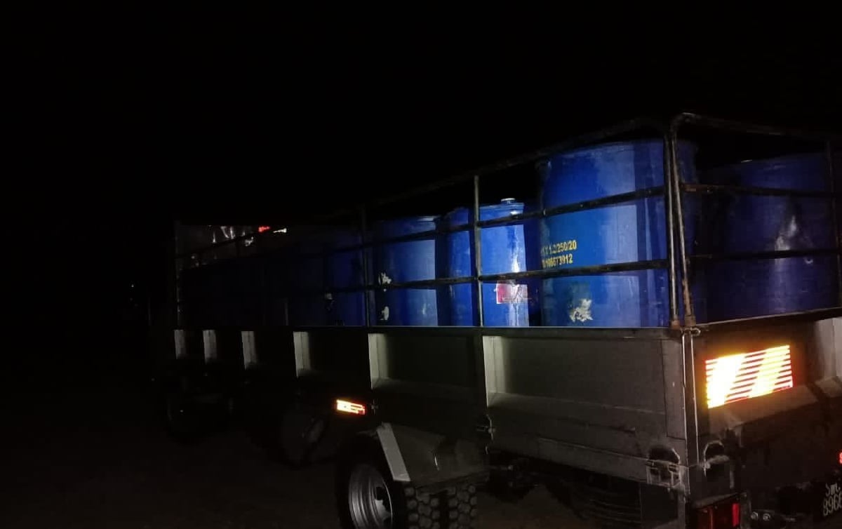 DUA lori yang membawa 58 tong berisi minyak petrol disita dalam serbuan di sebuah stesen minyak di Batu 32, Sandakan. FOTO ihsan PGA