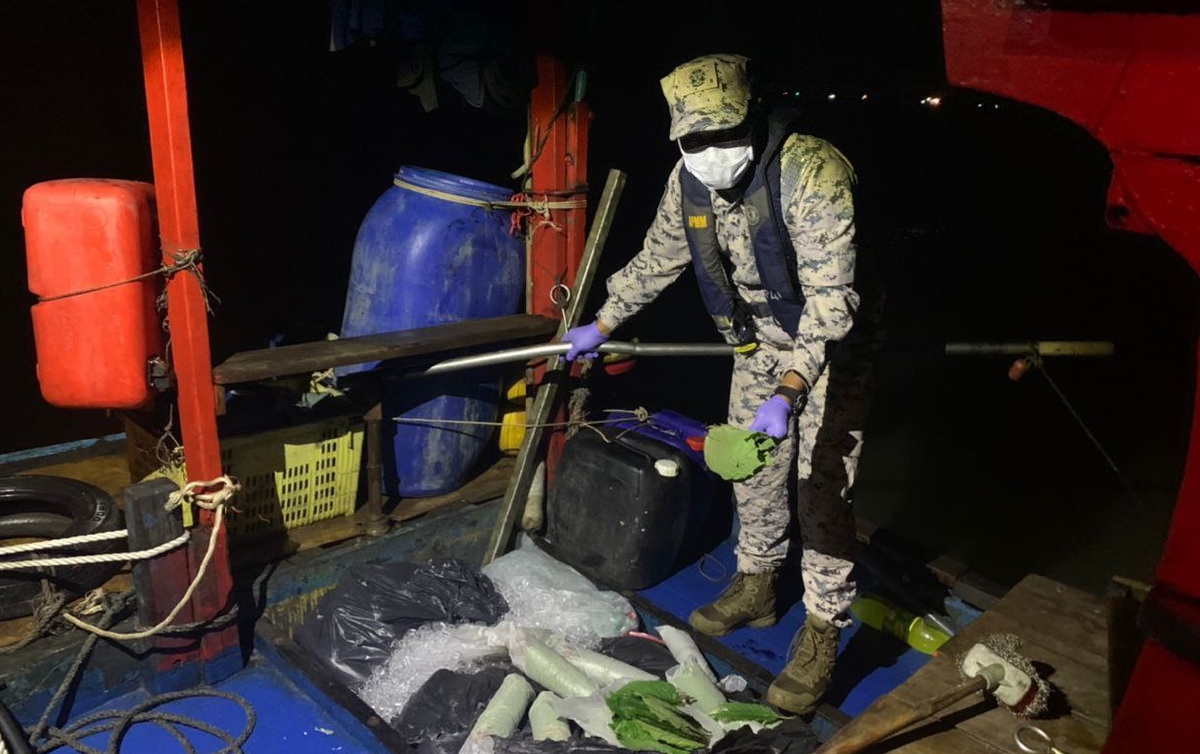 AGGOTA APMM Zon Maritim Kuala Kedah memeriksa bungkusan yang mengandungi 1.3 tan daun ketum dalam sebuah bot nelayan tempatan. FOTO ihsan APMM