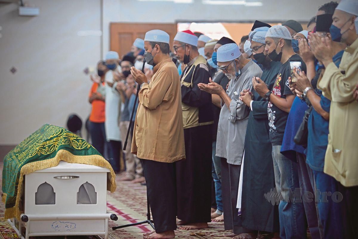 AYAH Arwah, Mohd Omar (baju kelabu) membaca doa untuk anaknya, Adibah Noor yang meninggal dunia akibat penyakit kanser ovari tahap empat. FOTO Azhar Ramli