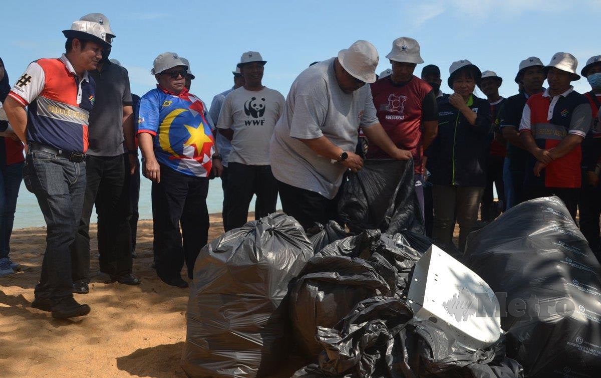 AB Rauf meneliti sampah yang dikutip di pantai peranginan Padang Kemunting, dekat Masjid Tanah pada program Kempen Berani Tegur Demi Perlindungan Penyu dan Alam Sekitar hari ini. FOTO Hassan Omar