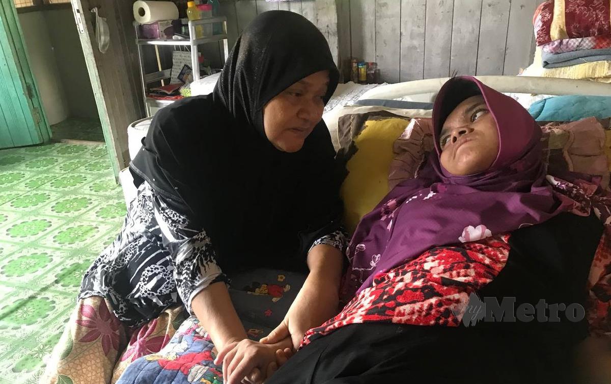 SITI Zubaidah yang mengalami masalah penglihatan tabah menjaga anak bongsunya, Nur Athirah Najihah yang telantar dan menghidap Cerebral Palsy ketika ditemui di rumah sewanya di di Kampung Pangkal Changgong, Machang. FOTO Hazira Ahmad Zaidi