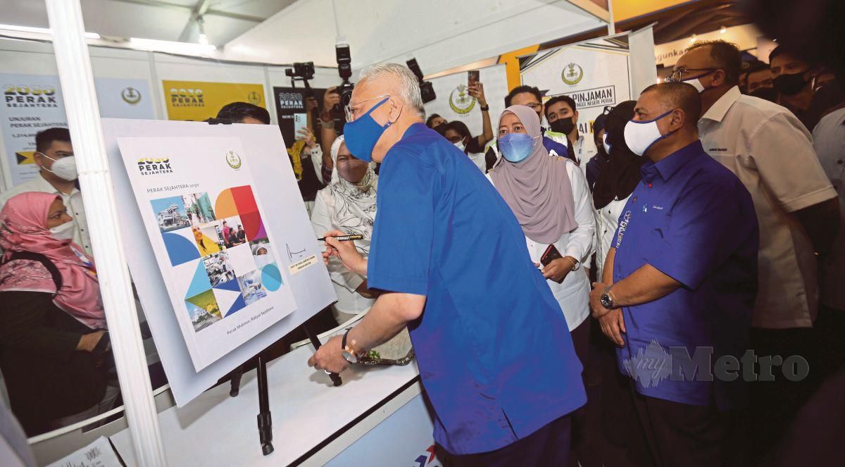 ISMAIL Sabri (kiri) menandatangani Plak Perak Sejehtera 2030 ketika melawat tapak pameran Setiausaha kerajaan Perak di Litar Dato Sagor Kampung Gajah Pasir Salak. FOTO L Manimaran