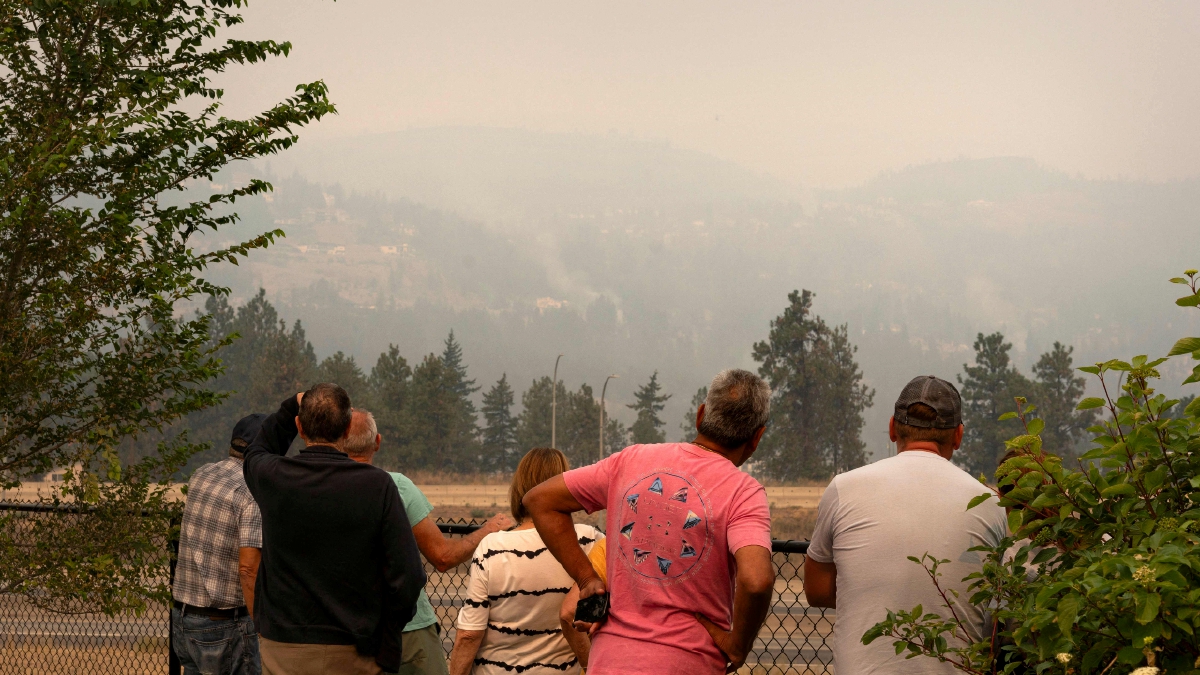 Penduduk tempatan McDougall Creek di Kelowna Barat, Kanada British Columbia memerhatikan kebakaran hutan yang semakin menghampiri tempat tinggal mereka. - FOTO AFP