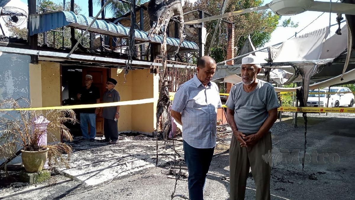 Datuk Sulaiman Abdul Razak bersama mangsa kebakaran, Marni Selamat ketika ditemui di Kampung Parit Serong, hari ini. FOTO AMIRUL AIMAN HAMSUDDIN