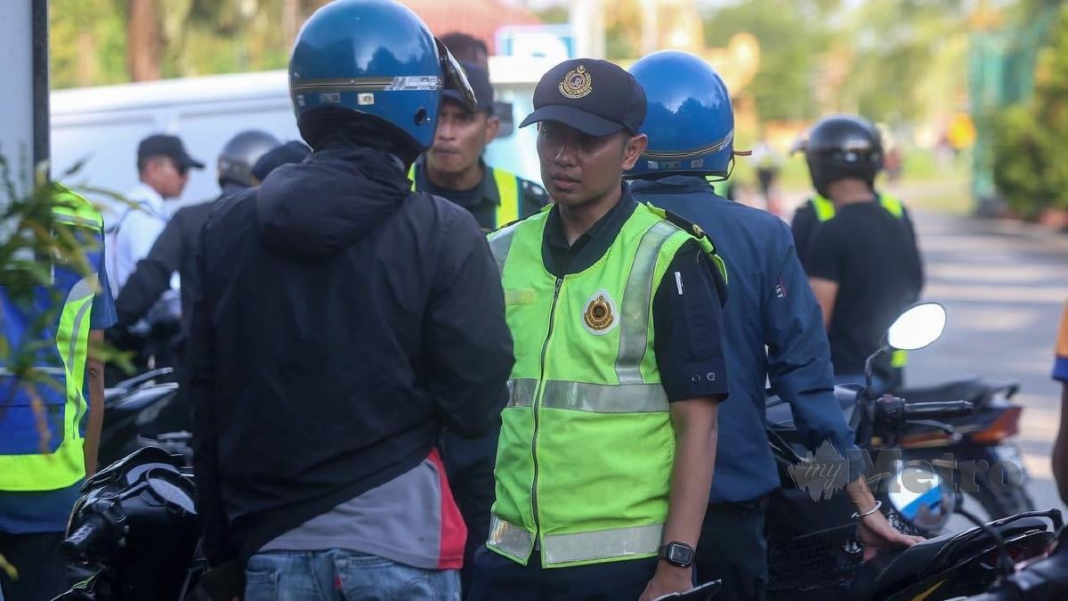 Penguatkuasa Jabatan Pengangkutan Jalan (JPJ) Pulau Pinang memeriksa penunggang motosikal dalam Ops Khas Perayaan Hari Raya Aidilfitri (HRA) di Stesen Penguatkuasa JPJ Valdor. FOTO DANIAL SAAD