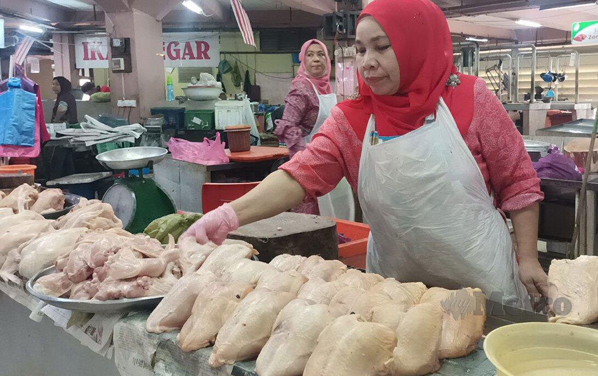 SARIMAH Dolah menunjukkan ayam bersaiz sederhana yang dijual di gerainya pada harga antara RM8 hingga RM8.50 sekilogram. FOTO Siti Rohana Idris